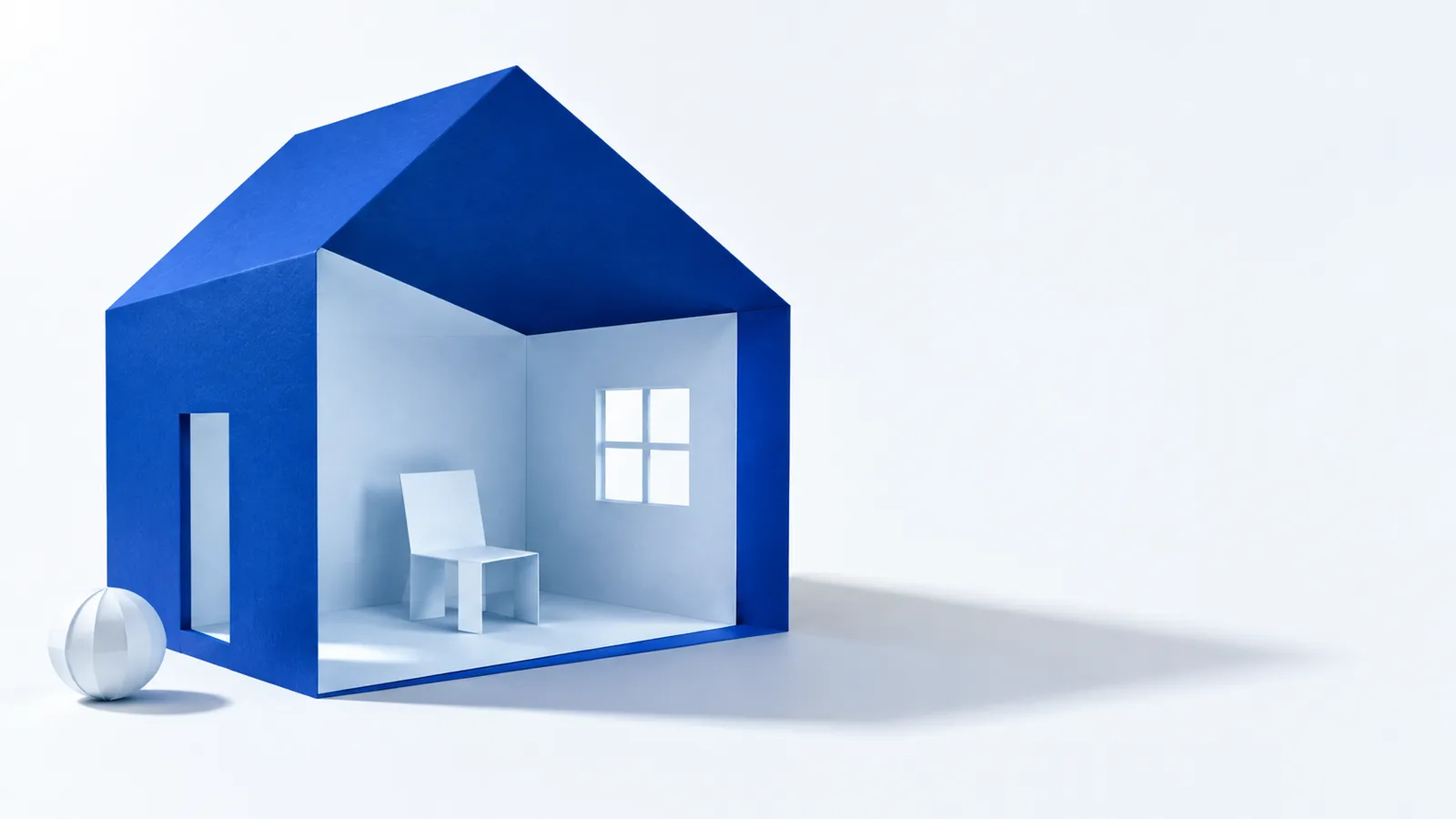 A paper room with a window and chair set inside a larger cobalt building outline.
